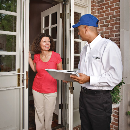 Plumber in Alpharetta, GA, speaking with customer on her front porch.