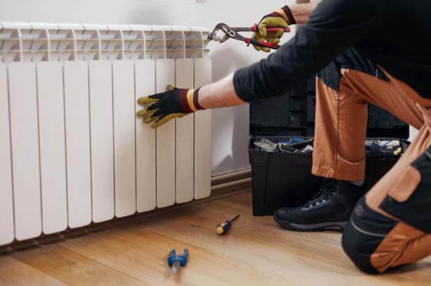 Central heating mechanic and handyman fixing home radiator