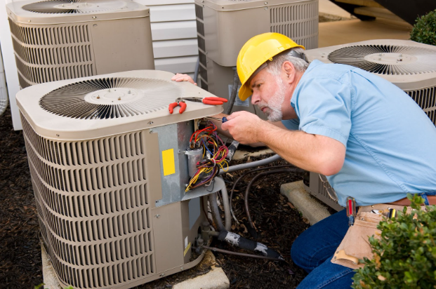 Repairman works on outdoor HVAC unit
