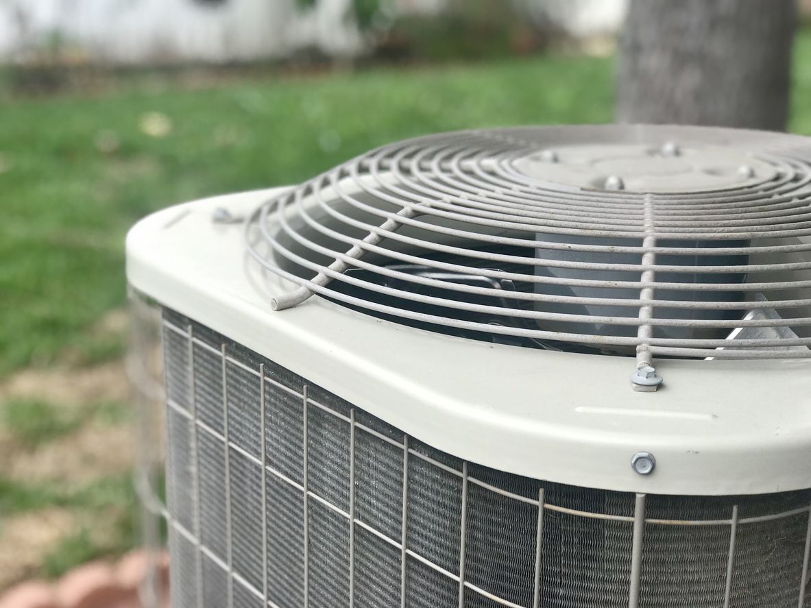 Close-up of an outdoor air conditioner condenser fan not spinning.